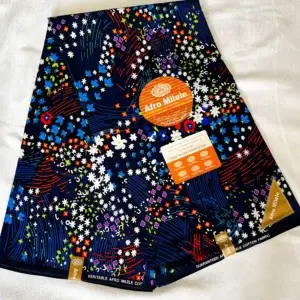 Premium Ankara/Kitenge fabric featuring floral and star patterns in blue, white, red, green, orange, and purple on a durable cotton base.