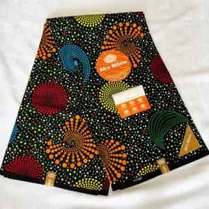 Premium Kitenge fabric featuring colorful dotted circular patterns on a bold black cotton base, crafted for durable use.