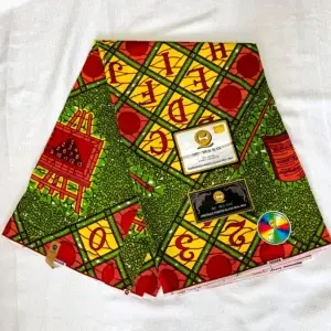 Premium Ankara/Kitenge fabric featuring vibrant yellow and green backgrounds with bold red circular patterns and lettering, crafted from durable cotton.