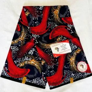 Premium Ankara/Kitenge fabric featuring red and gold swirling patterns accented by white dots on a dark blue cotton base.