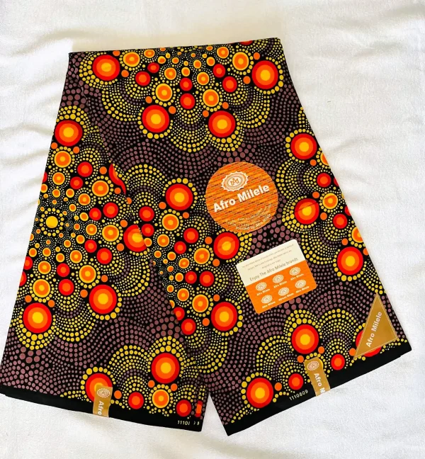 Premium Ankara/Kitenge fabric with bold concentric circle patterns in vibrant yellow, orange, and red on a deep black background.