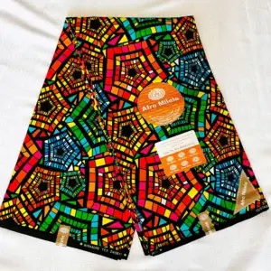 Premium Kitenge fabric featuring bold multicolor geometric patterns in red, orange, yellow, green, and blue on a black cotton base.