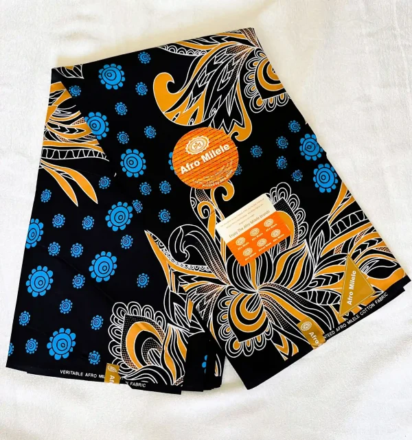 Premium Ankara/Kitenge fabric with deep black background, featuring blue circular floral motifs and flowing abstract shapes in gold and white.