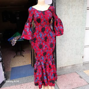 A red and blue patterned off-shoulder Kitenge dress with flared sleeves and an elastic, form-fitting design suitable for all sizes.