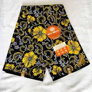 Premium Cotton Kitenge fabric with bold yellow floral patterns and white swirls on a rich dark blue base, featuring authentic branding labels.