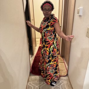 Long, colorful Kitenge dress with red, yellow, green, and black patterns. Made with high-quality, durable fabric and customizable design.