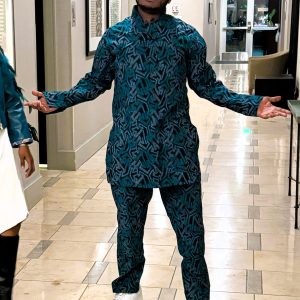 Traditional men’s outfit featuring a green and black Kitenge design with white dotted accents. Includes a long-sleeved shirt and pants.